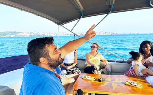 Guide explaining sights during Bosphorus & Golden Horn sunset yacht cruise.