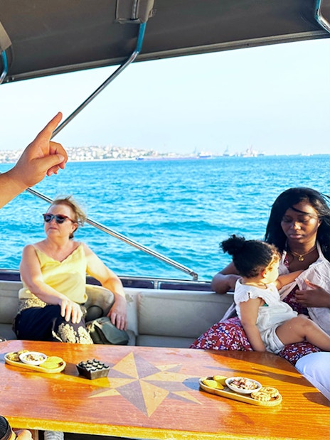 Guide explaining sights during Bosphorus & Golden Horn sunset yacht cruise.