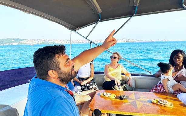 Guide explaining sights during Bosphorus & Golden Horn sunset yacht cruise.