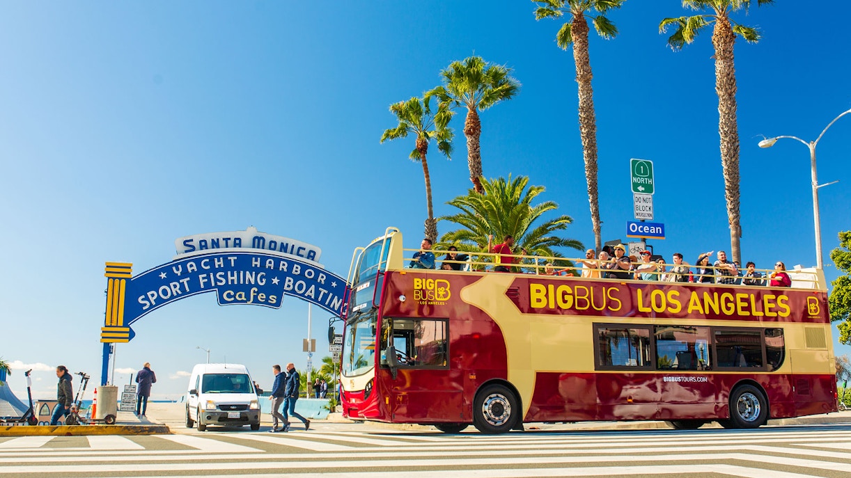 Ein Los Angeles Hop-On Hop-Off Bus des Anbieters Big Bus Los Angeles fährt am Santa Monica Pier vorbei