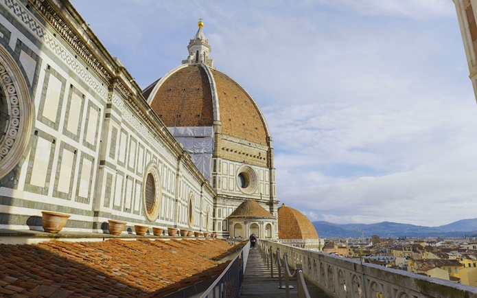 Terrace view of Florence Cathedral with dome and cityscape in the background.