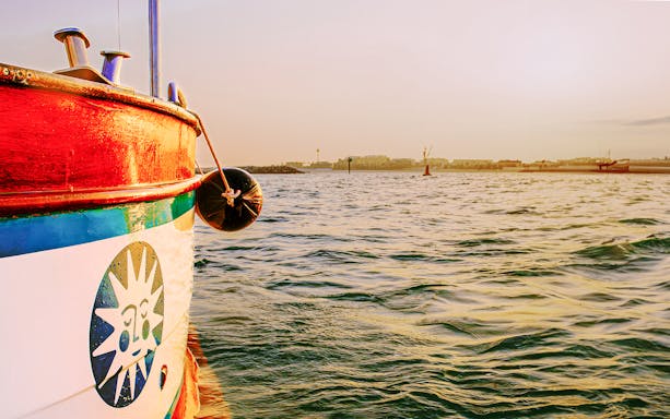 Colorful boat on Jumeirah waters during sunset, part of the Jumeirah Swimming Tour.