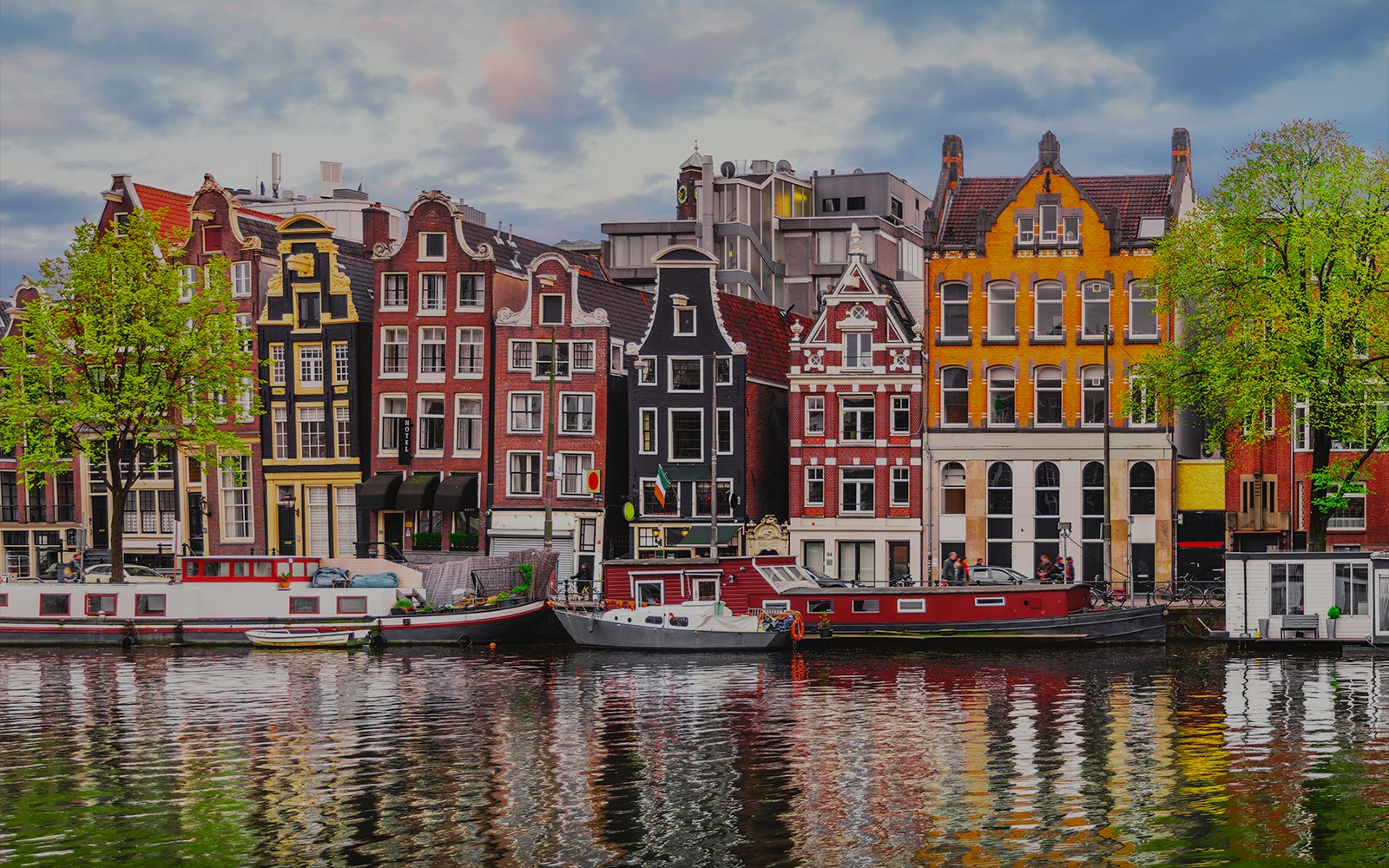 Amsterdam open boat cruise with view of iconic Dancing Houses and canal.