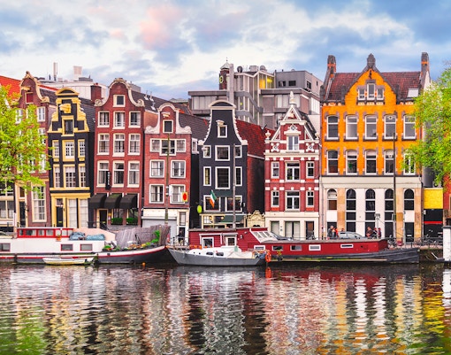 Amsterdam open boat cruise with view of iconic Dancing Houses and canal.