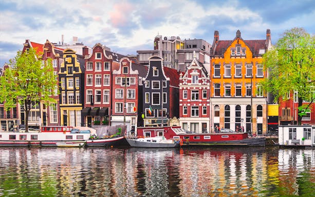 Amsterdam open boat cruise with view of iconic Dancing Houses and canal.