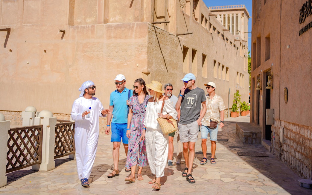 Guide leading tourists through historic Middle Eastern street.
