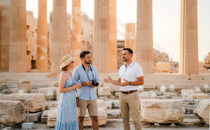 Tour guide explaining the Parthenon to visitors at the Acropolis.