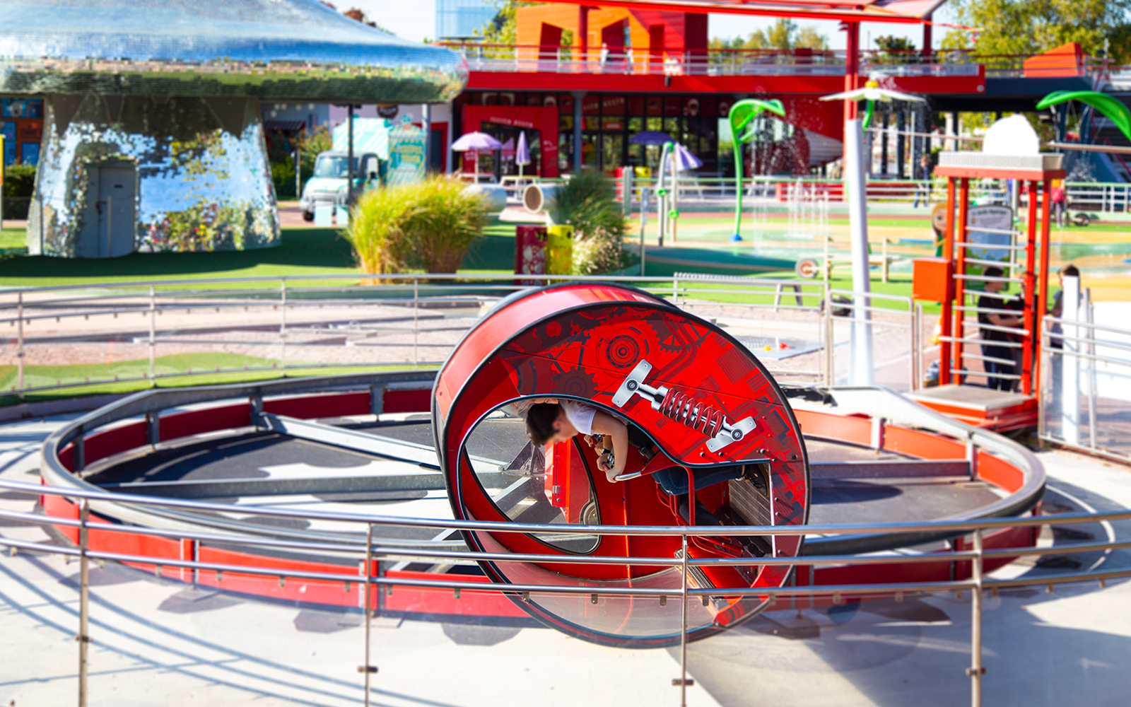 Centrifuge ride at Futuroscope theme park with a person inside the rotating capsule.
