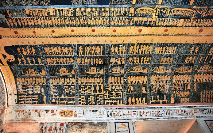 Ancient Egyptian hieroglyphs on a tomb ceiling in the Valley of Kings, Luxor, Egypt.
