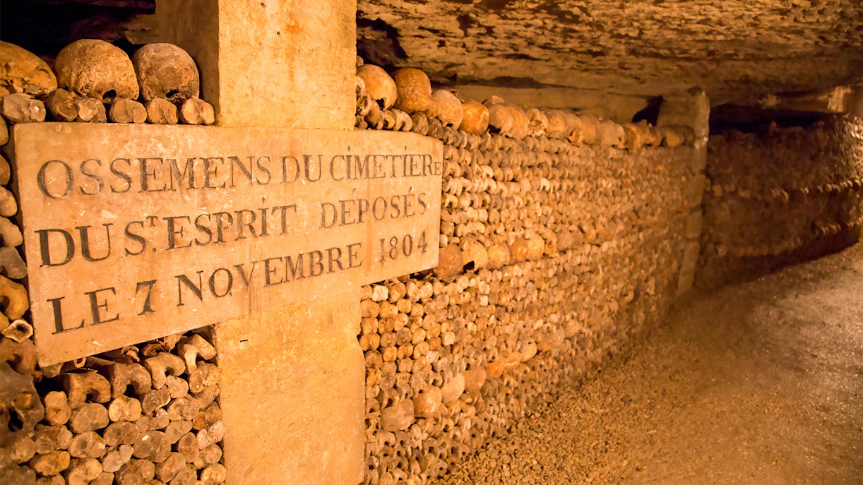 Skulls and bones stacked in the Paris Catacombs with an inscription dated 1804.