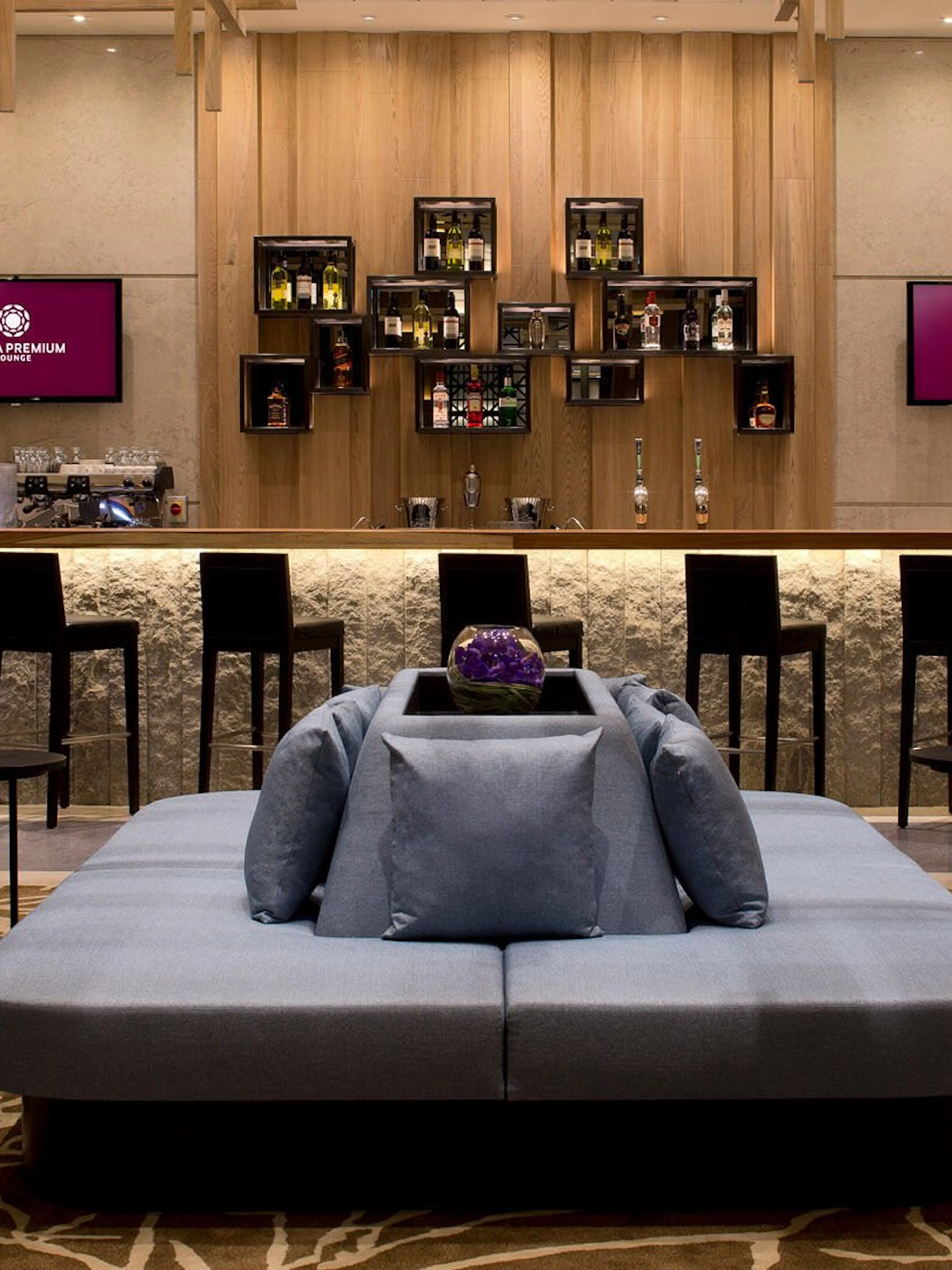 Plaza Premium Lounge seating area and bar at London Heathrow Airport.