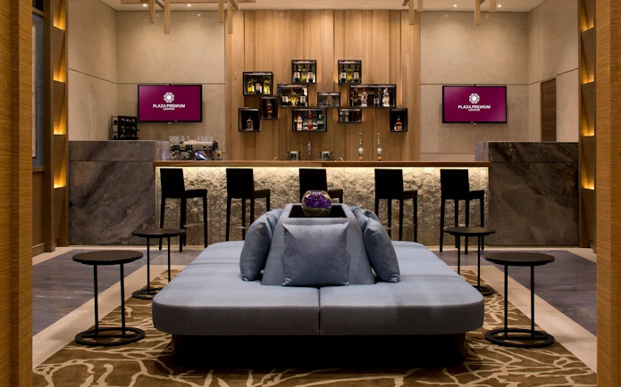 Plaza Premium Lounge seating area and bar at London Heathrow Airport.