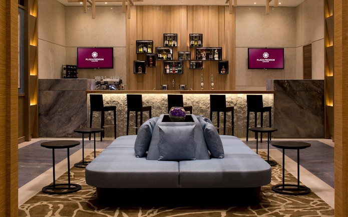Plaza Premium Lounge seating area and bar at London Heathrow Airport.