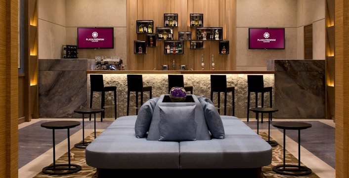 Plaza Premium Lounge seating area and bar at London Heathrow Airport.