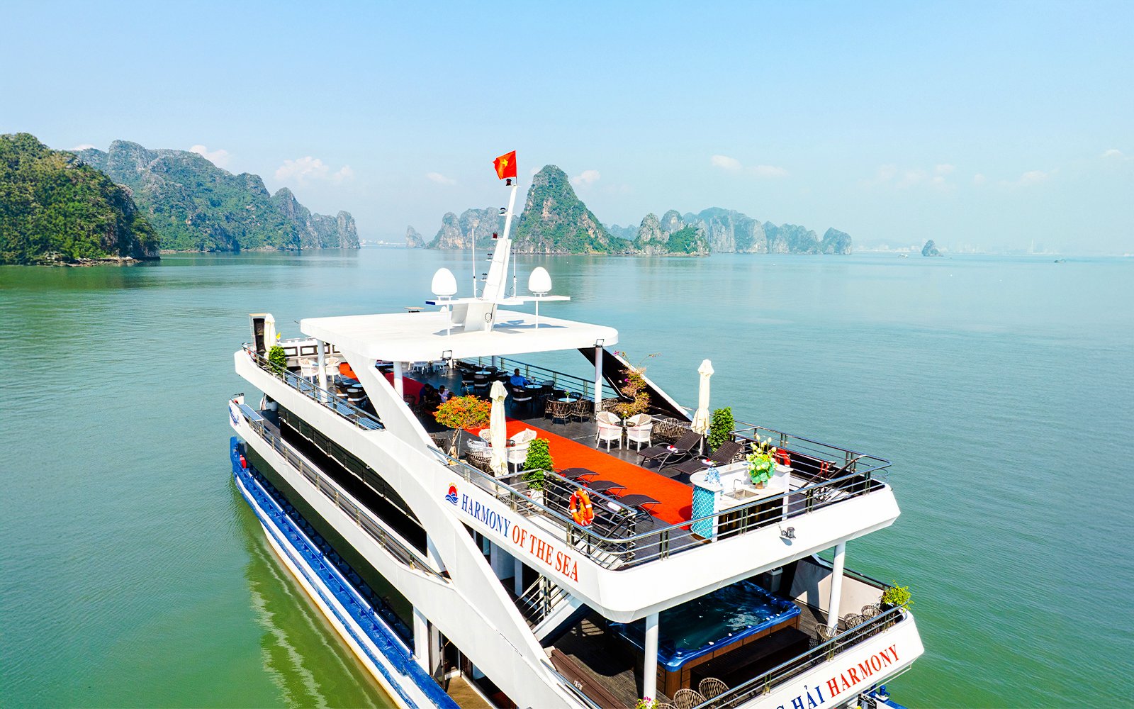 Aerial view of cruise ship deck in Ha Long Bay, Vietnam, with limestone islands in the background.