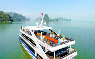 Aerial view of cruise ship deck in Ha Long Bay, Vietnam, with limestone islands in the background.
