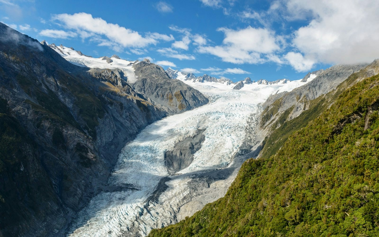 Aerial view of Fox Glacier surrounded by mountains on New Zealand's west coast.