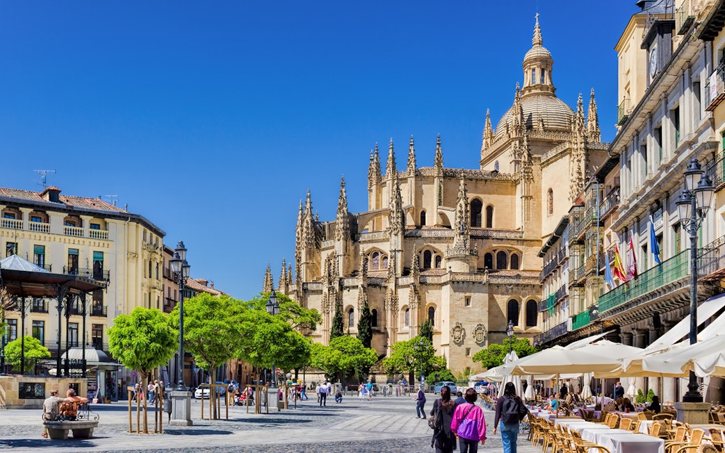 Segovia Cathedral with people walking in the plaza, Segovia, Spain.