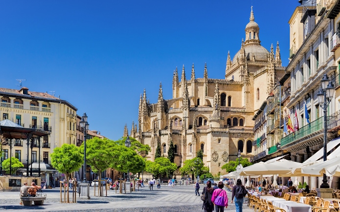 Segovia Cathedral with people walking in the plaza, Segovia, Spain.