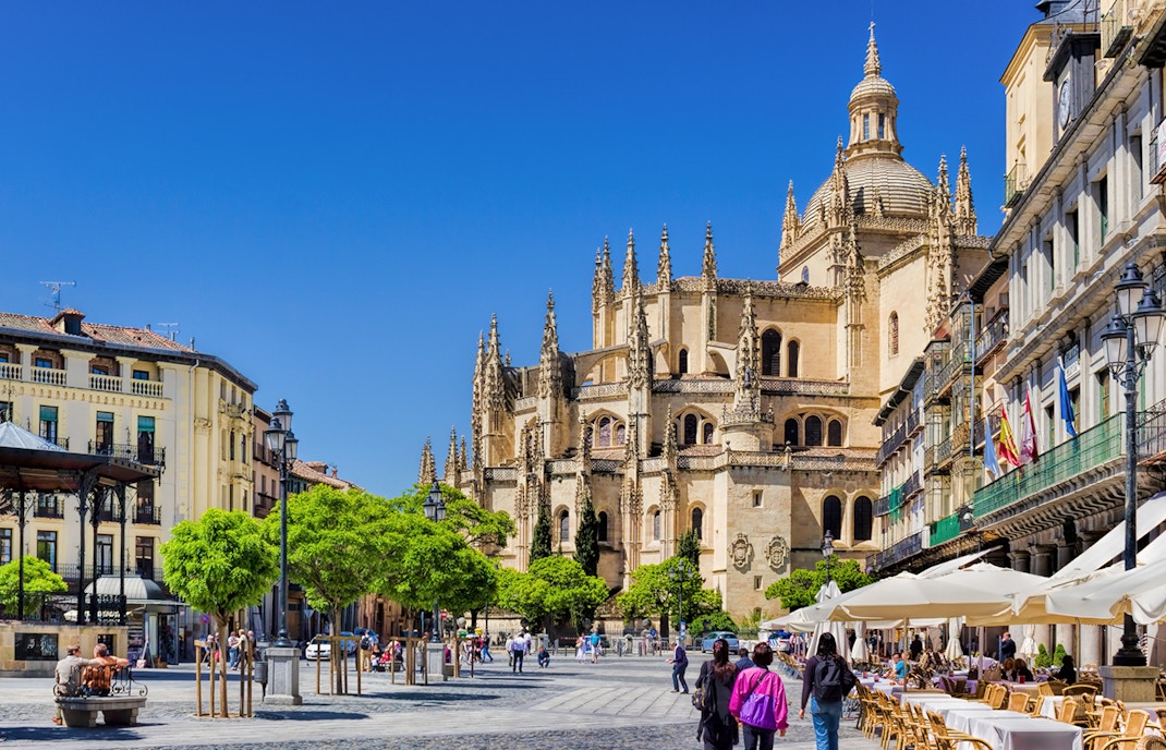 Segovia Cathedral with people walking in the plaza, Segovia, Spain.