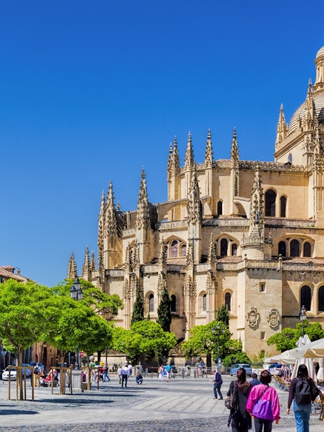 Segovia Cathedral with people walking in the plaza, Segovia, Spain.