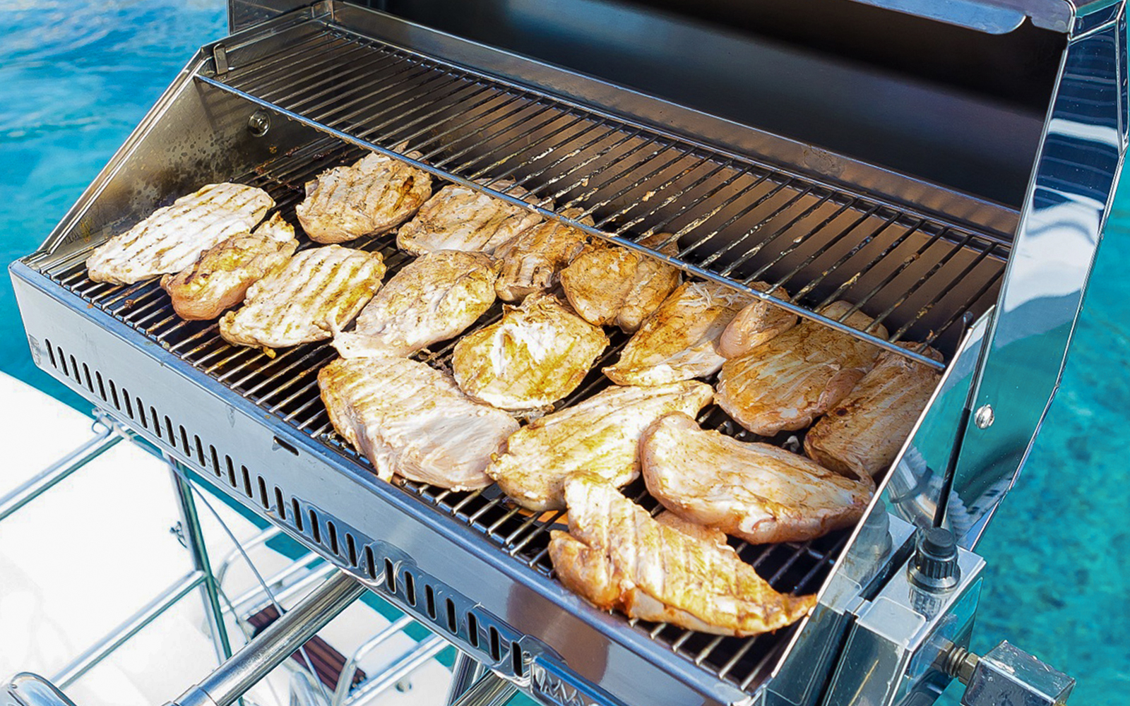 BBQ grilling on Santorini sailing catamaran cruise.