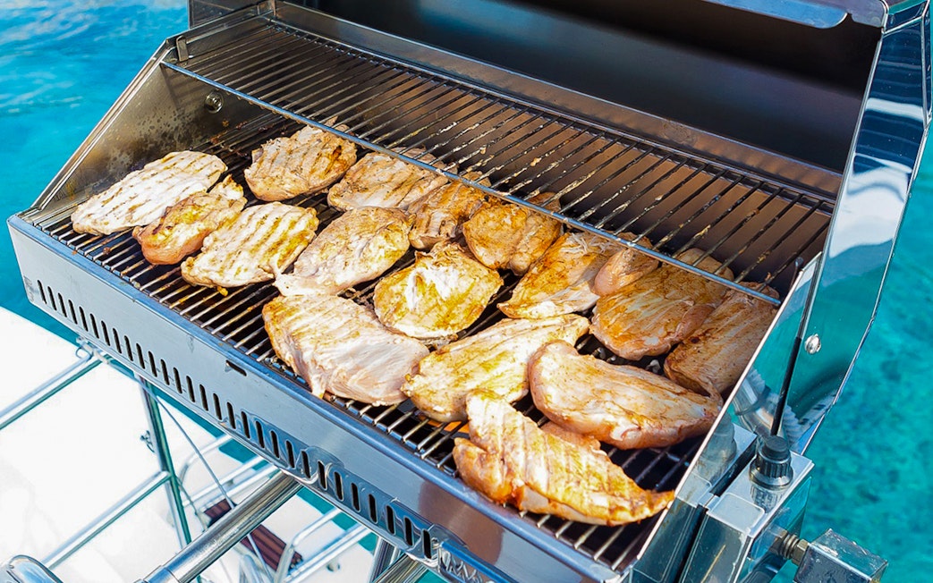 BBQ grilling on Santorini sailing catamaran cruise.