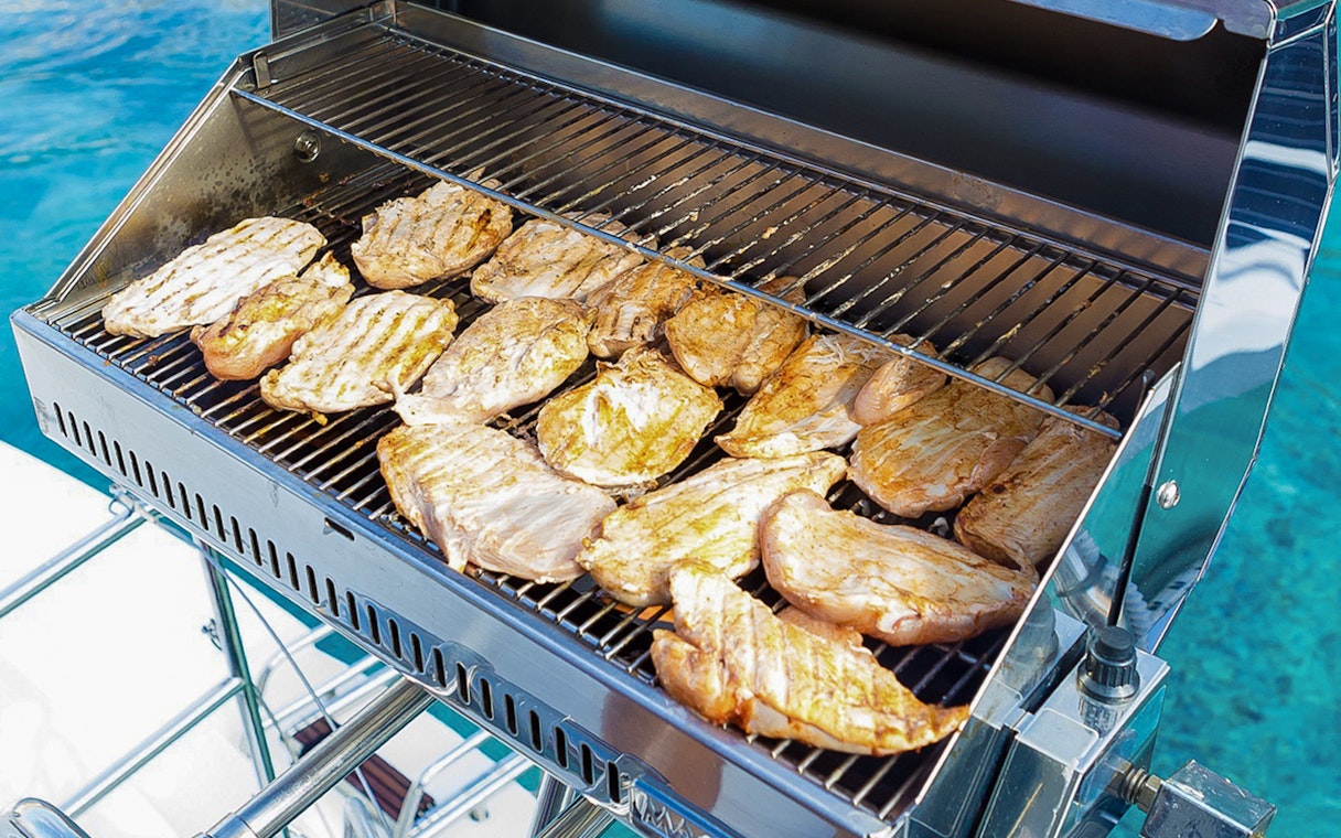 BBQ grilling on Santorini sailing catamaran cruise.