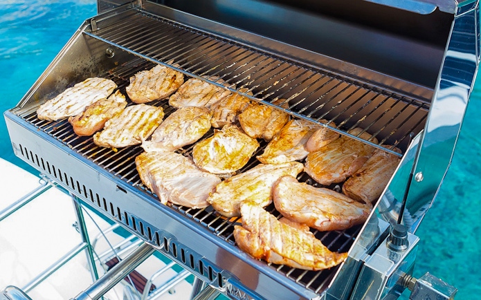 BBQ grilling on Santorini sailing catamaran cruise.