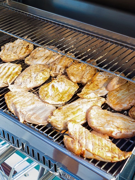 BBQ grilling on Santorini sailing catamaran cruise.