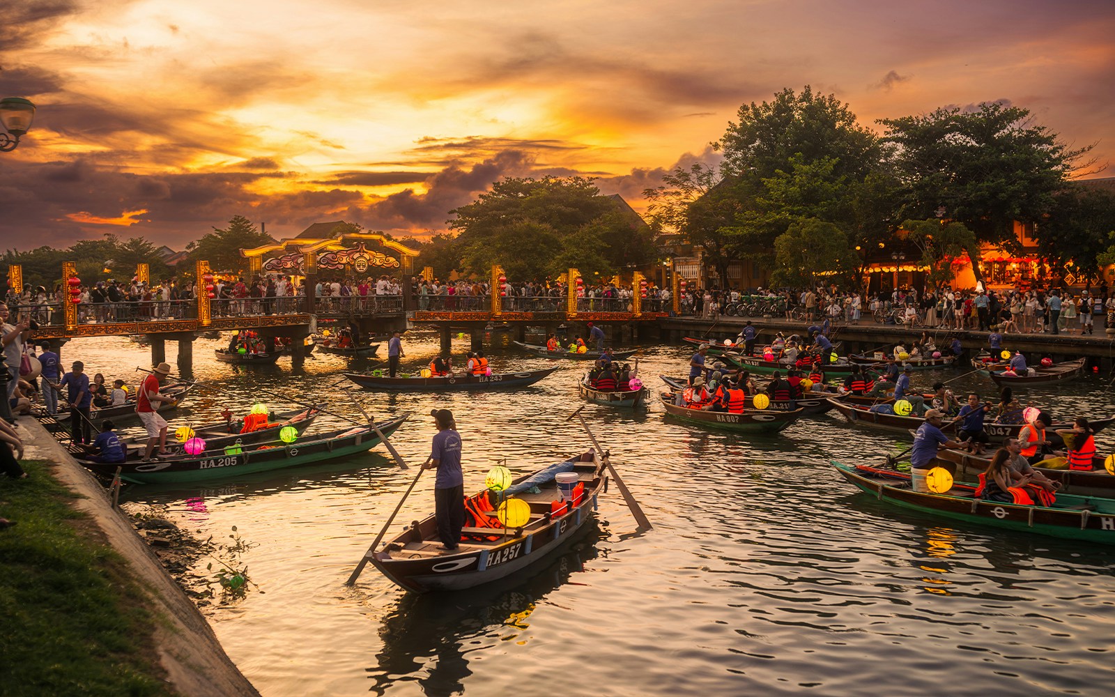 Lantern boats with tourists on the river in Hoi An, Vietnam during sunset.