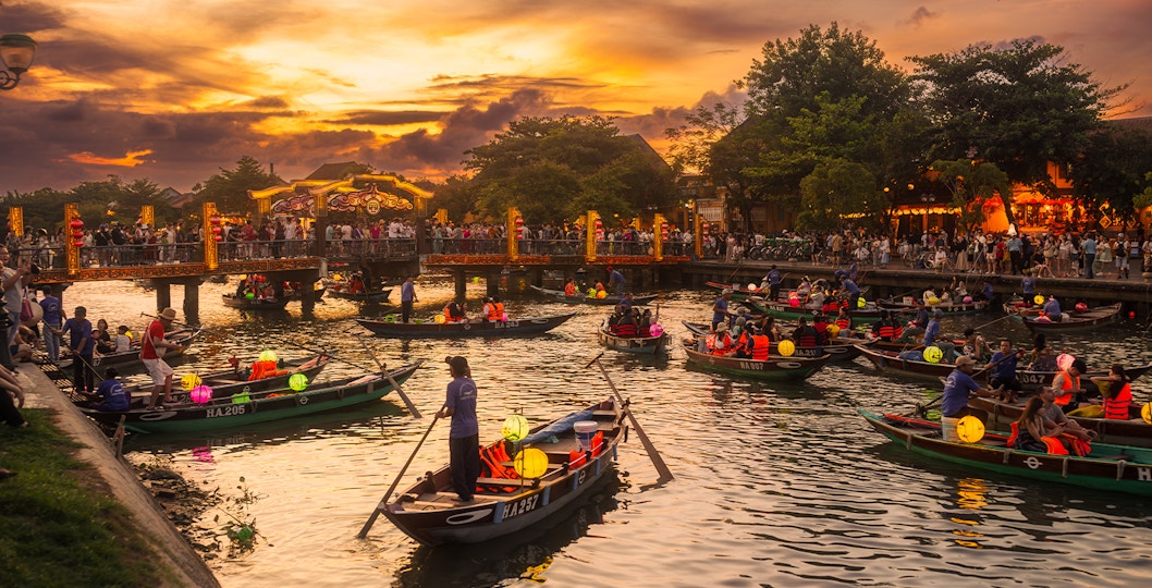 Lantern boats with tourists on the river in Hoi An, Vietnam during sunset.