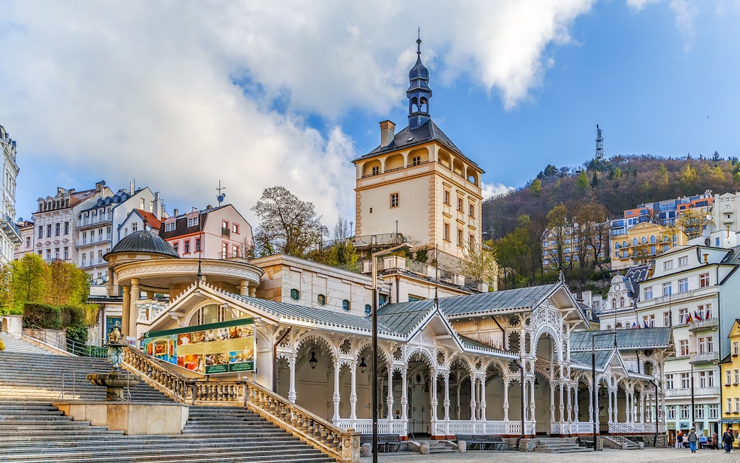 Karlovy Vary colonnade and historic buildings with Watchtower Diana in the background.