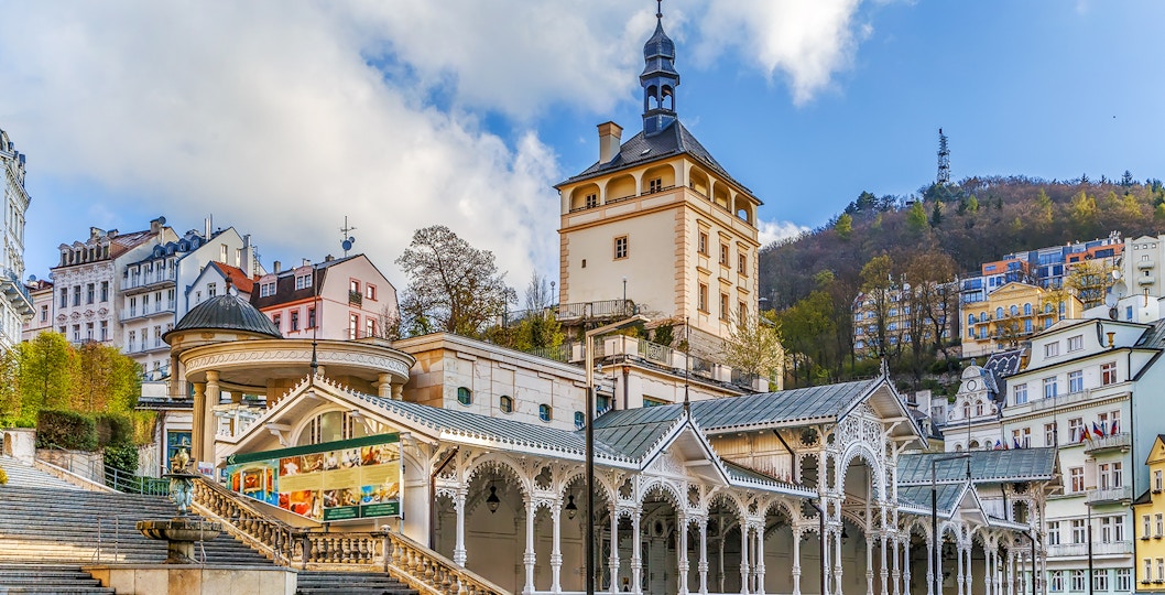Karlovy Vary colonnade and historic buildings with Watchtower Diana in the background.