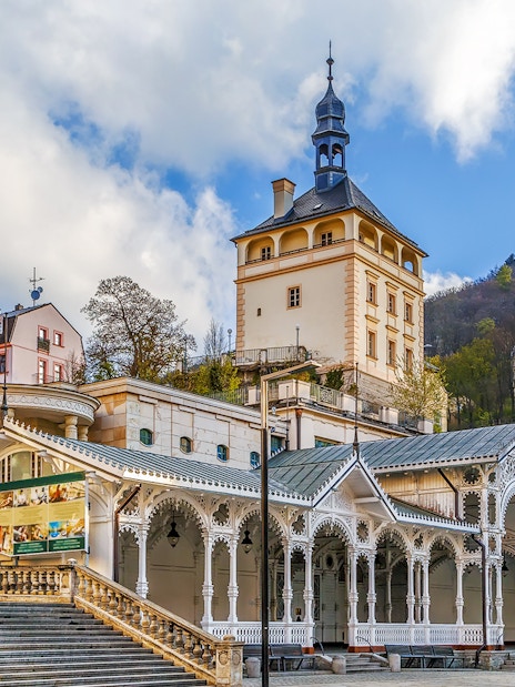 Karlovy Vary colonnade and historic buildings with Watchtower Diana in the background.