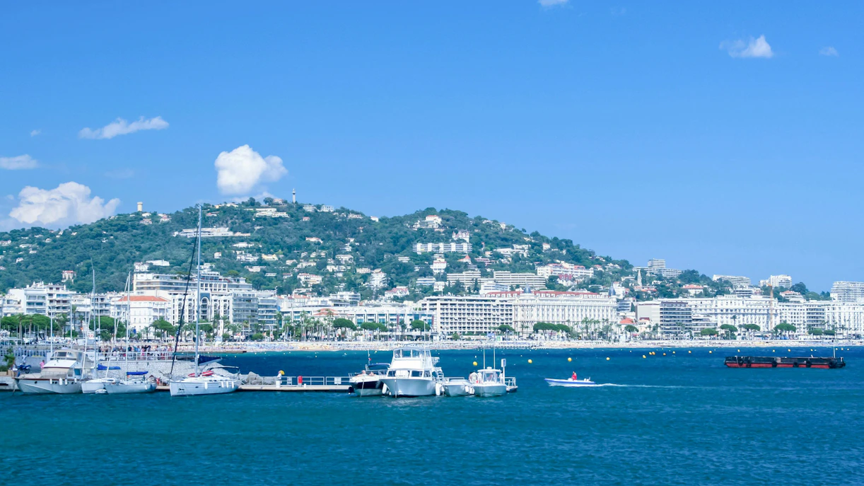 Yachts docked at Port Pierre Canto with Cannes cityscape in the background.