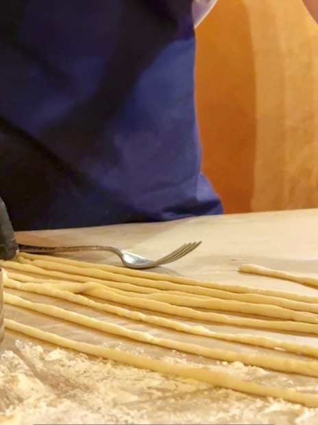 Participant preparing pasta during cooking class in Siena.