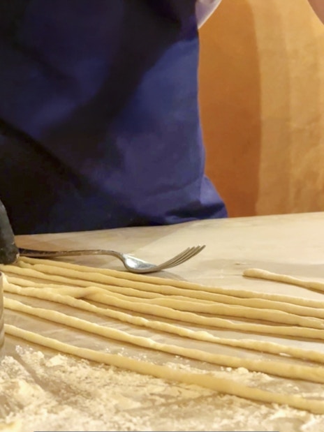 Participant preparing pasta during cooking class in Siena.