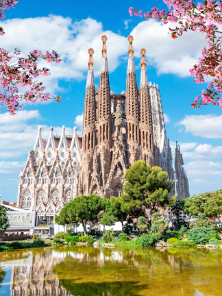Sagrada Familia basilica in Barcelona with reflection in pond.