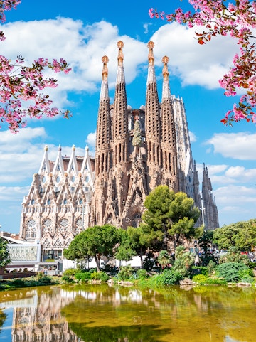 Sagrada Familia basilica in Barcelona with reflection in pond.