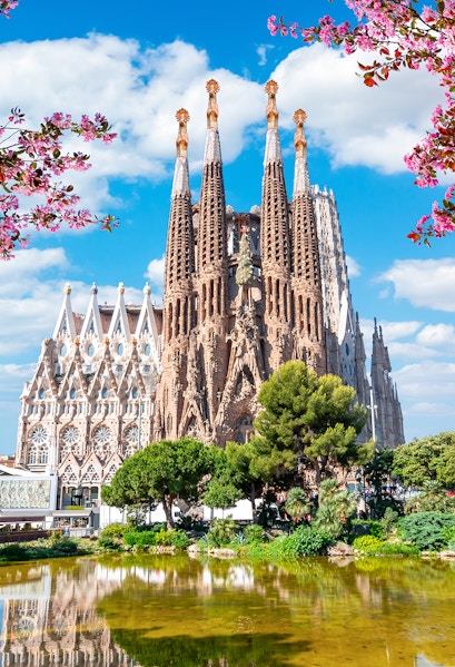 Sagrada Familia basilica in Barcelona with reflection in pond.