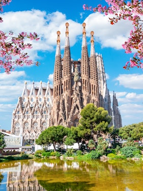Sagrada Familia basilica in Barcelona with reflection in pond.