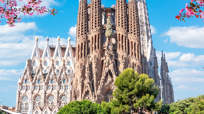 Sagrada Familia basilica in Barcelona with reflection in pond.
