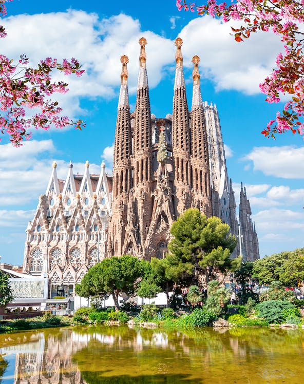 Sagrada Familia basilica in Barcelona with reflection in pond.