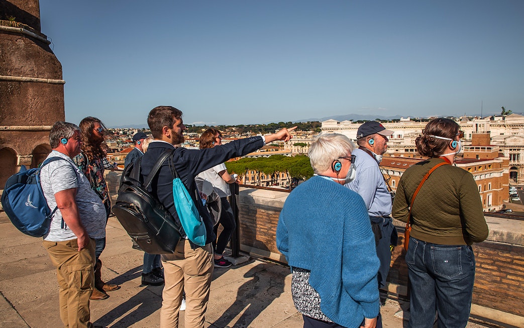 Tour group with guide overlooking Rome from Castel Sant'Angelo rooftop.