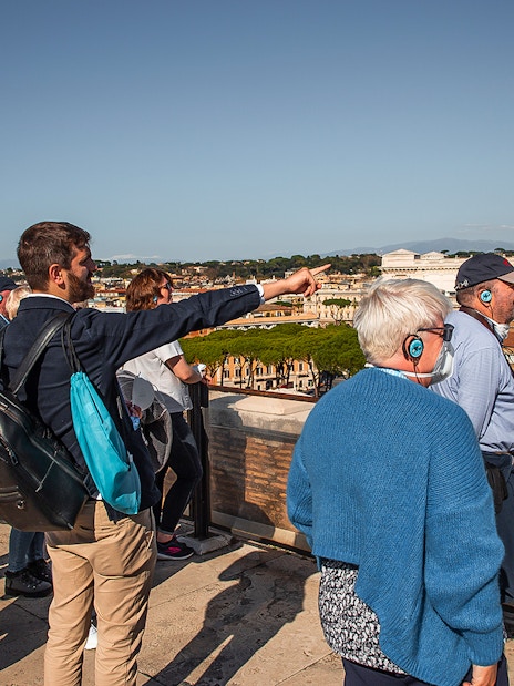 Tour group with guide overlooking Rome from Castel Sant'Angelo rooftop.