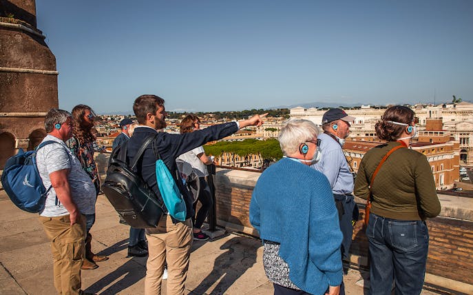 Tour group with guide overlooking Rome from Castel Sant'Angelo rooftop.