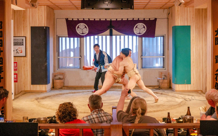 Sumo wrestlers competing in a match during a family workshop in Tokyo.