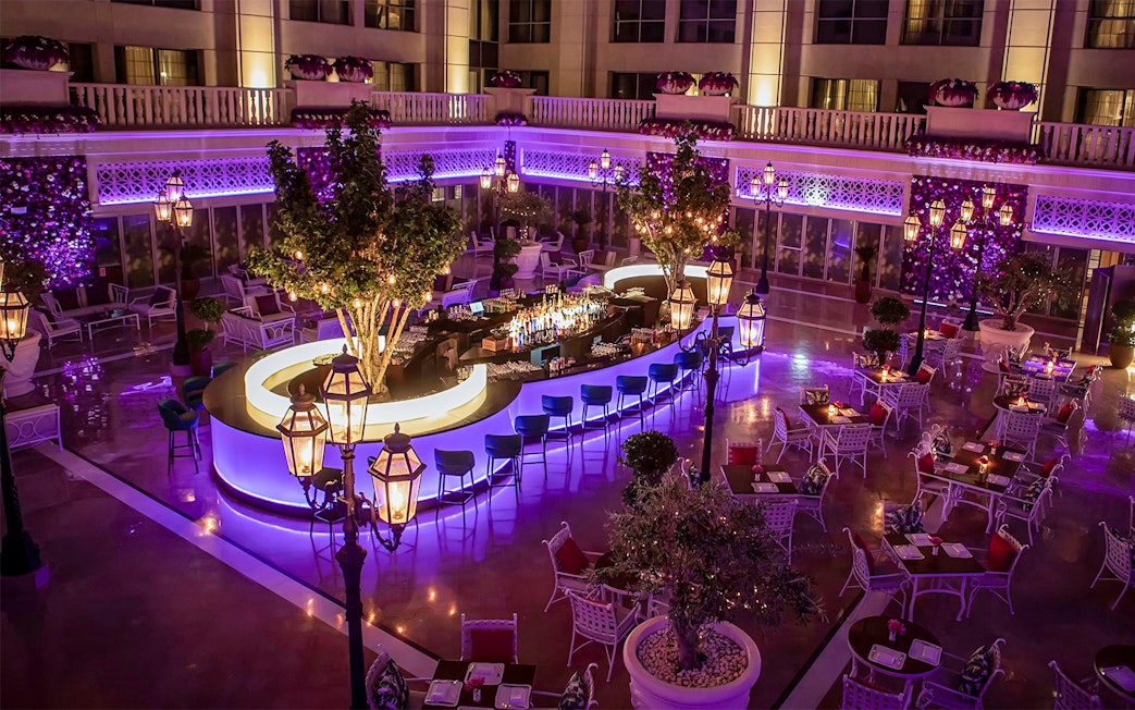 Outdoor dining area at Le Patio Restaurant with illuminated bar and seating, Dubai.