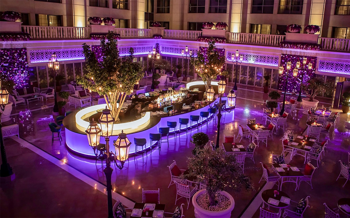 Outdoor dining area at Le Patio Restaurant with illuminated bar and seating, Dubai.